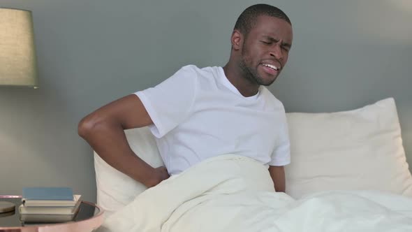 Exhausted Young African Man Having Back Pain in Bed