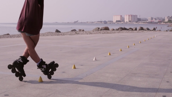 Young Beautiful Girl Rollerblading In A Park.