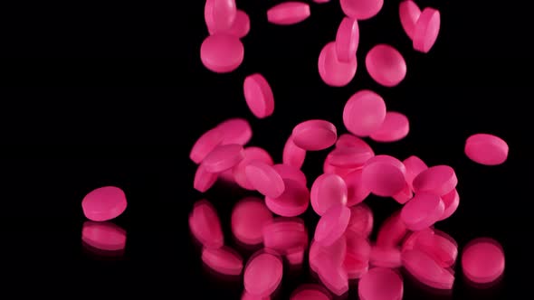 Super Slow Motion Shot of Falling Pink Pills on Black Background at 1000Fps