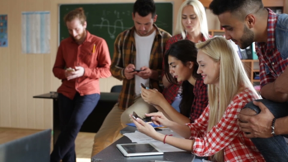 Students Using Smart Phone Sitting Desk University Classroom