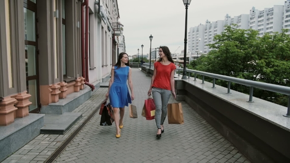 Happy Young Women Friends Walking With Shopping Bags, Talking Discuss Having Fun.  Stedicam Shot