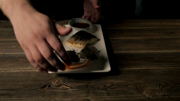 Healthy Food Concept: Chief Serving Hot Baked Fish Piece Over White Plate On Wooden Table