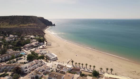 Wide Praia da Luz shoreline along vast horizon line on Algarve coast - Aerial