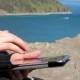 Female Sitting On The Shore Of Lake Baikal On a Rock And Using a Tablet - VideoHive Item for Sale