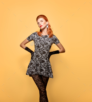 ayful Model Redhead girl in stockings, Luxury dress,accessories.Trendy Hairstyle.Unusual fall fashion creative vogue.Glamour fashion,orange. Vintage.