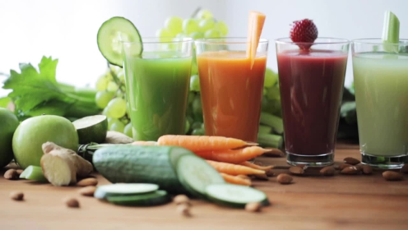 Glasses Of Juice, Vegetables And Fruits On Table