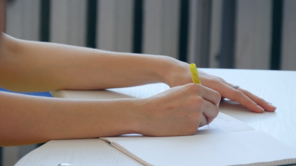 Hand Of Young Girl Write On Notebook In Scholl Or Colledge.
