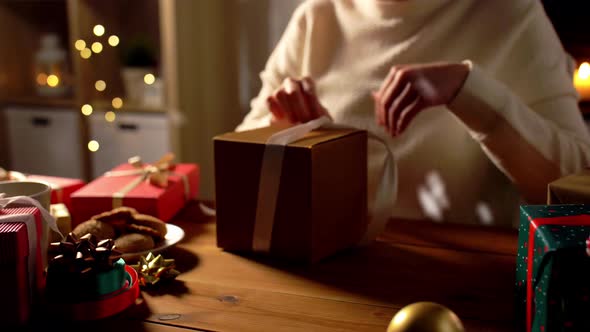 Woman Opening Christmas Gift at Home