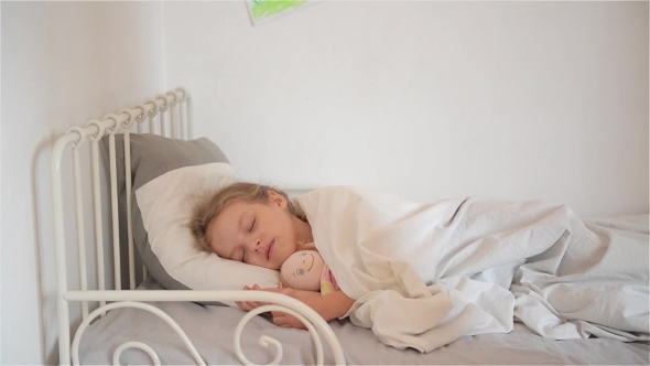 Woman Waking Young Girl In Bed