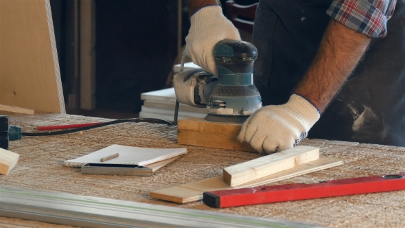 Man Working With Wooden Planck And Electric Planer Write In Notebook