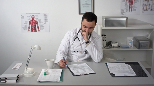 Thinking Out Loud. Thoughtful Young Bearded Doctor In Medical Cabinet.