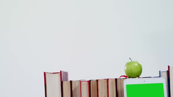 Apple, digital tablet and books on white background