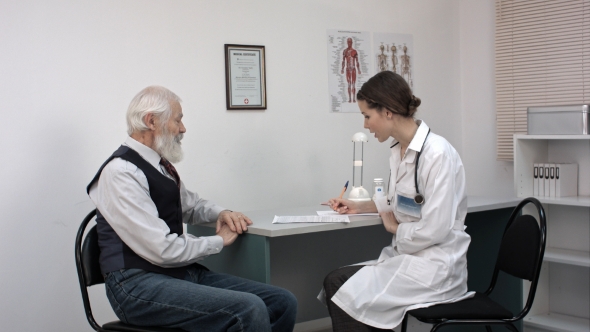 Doctor Talking To Senior Man At Her Office.