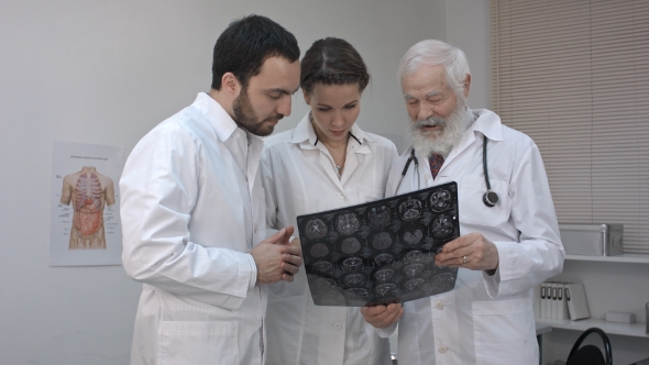 Group Of Doctors Checking An MR Exposure.