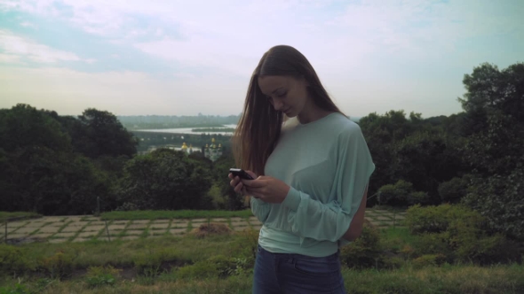 A Young Girl Is Gaining a Message On The Phone.