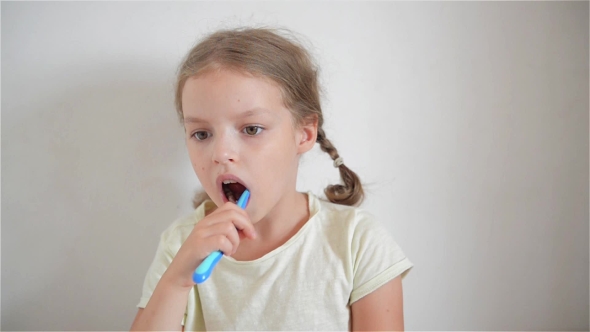 A Little Girl Brushing Her Teeth With a Brightly Colored Toothbrush