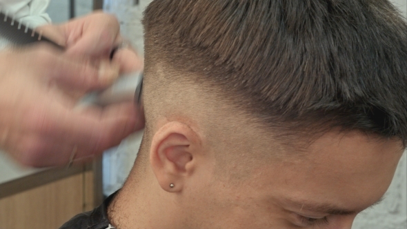 Hairdresser Cutting With Trimmer Hair Of Man Client At Beauty Parlour