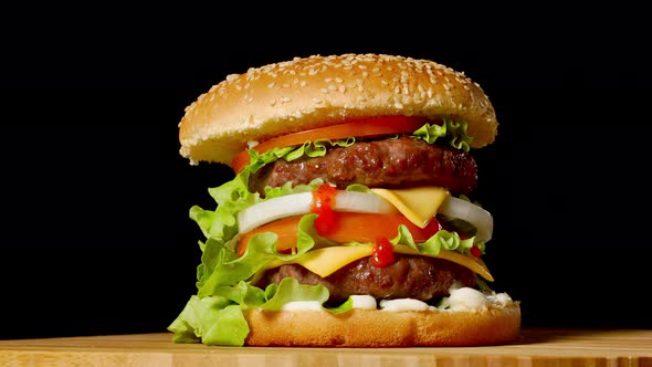Great Burger with Beef Cutlet, Tomatoes, Mushrooms and Cucumbers with Melted Cheese Rotates on a