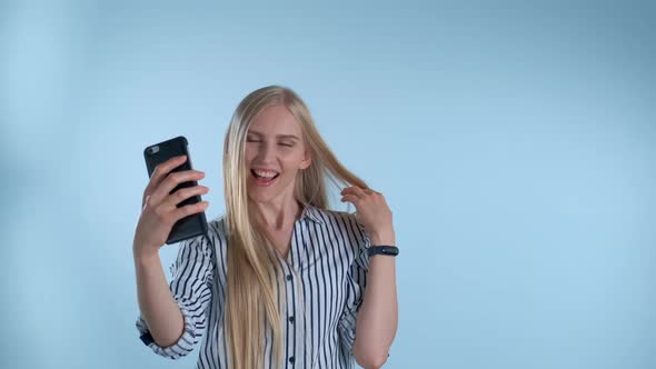 Attractive Blonde Lady Making Selfie on Smartphone on Blue Background