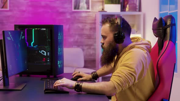 Professional Game Player Wearing Headphones in a Room with Colorful Neons