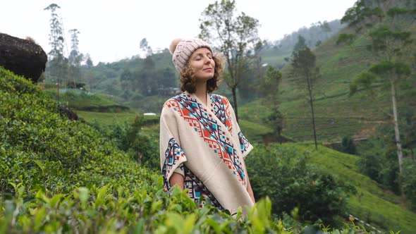 Happy Smiling Woman Standing In Green Field At Tea Plantation