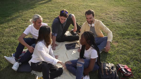 Diverse Classmates Chatting While Sitting on Lawn