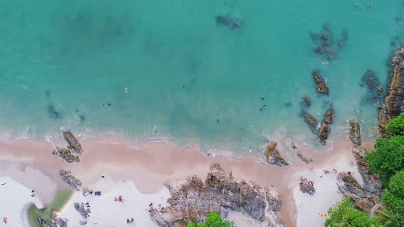 Aerial view of seashore rocks in ocean with coconut palm trees around phuket island.Beautiful sea