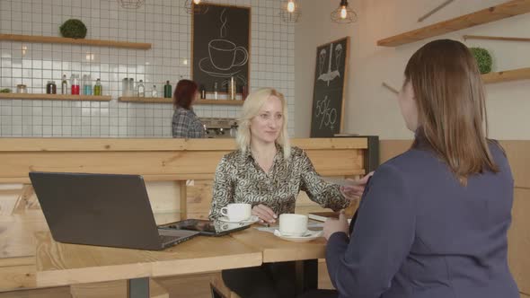 Businesswomen Handshaking Making Deal in Cafe