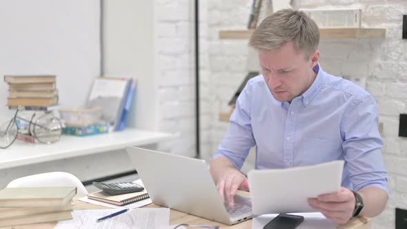 Businessman Reading Documents While Working