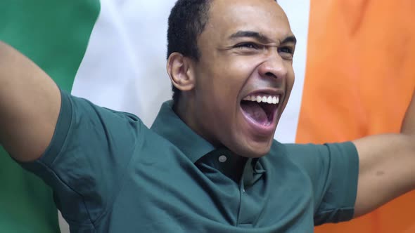 Irish Fan Celebrating while Holding the Flag of Ireland