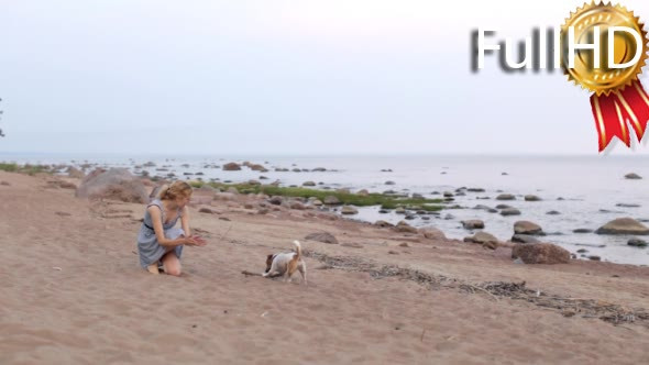 Girl Plays With a Dog on the Beach