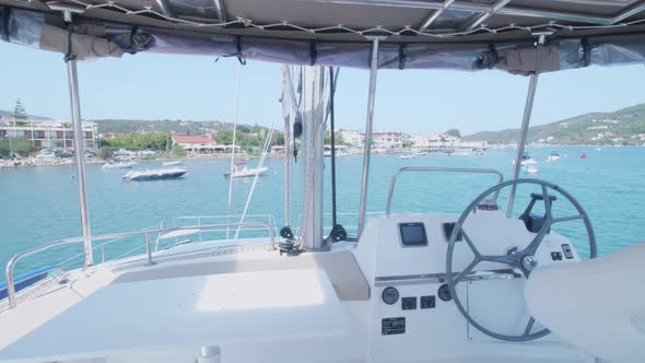 Exterior view of a sailboat steering wheel on a boat deck.