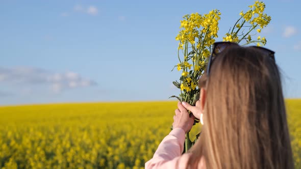 Happy Young Blonde on a Yellow Rapeseed Field