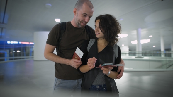 A Young Couple Talking About The Trip At The Airport