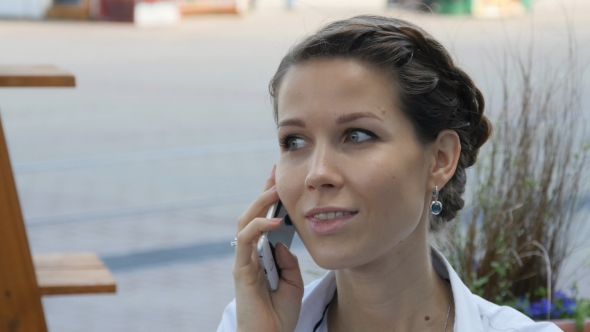 Pretty Young Woman Smiling While Calling Someone Through Mobile Phone.