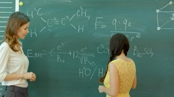 Student Writing Chemical Symbol On Blackboard
