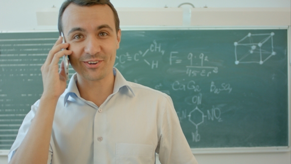 Man Talking Phone At Classroom In Front Of Chalkboard