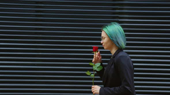 Girl Going at Street Inhales Fragrance of Red Rose