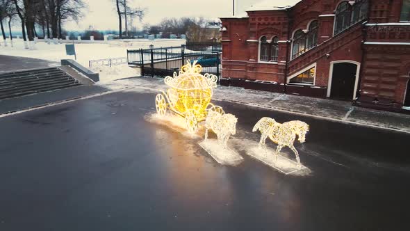 A Carriage with Horses Made of Glowing Golden Garlands on the City Square