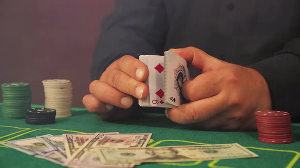 Hands of a Risky Poker Player Closeup Slowly Fingering a Deck of Cards