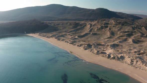 Video over beautiful wild beach with sand dunes and clear waters