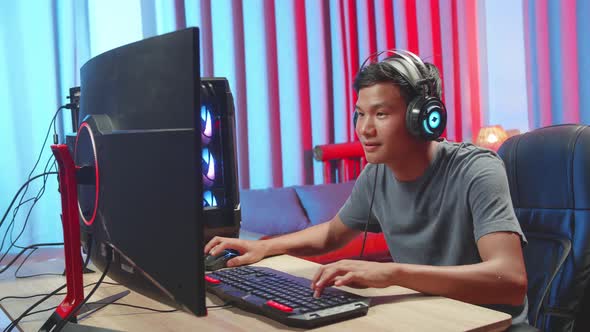 Excited Asian Gamer man playing game