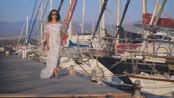 Beautiful Woman Walking On a Pier On a Summer Day