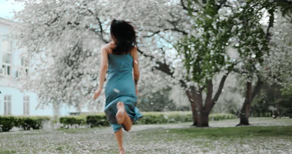 Asian Woman Walking Through a Blooming Garden