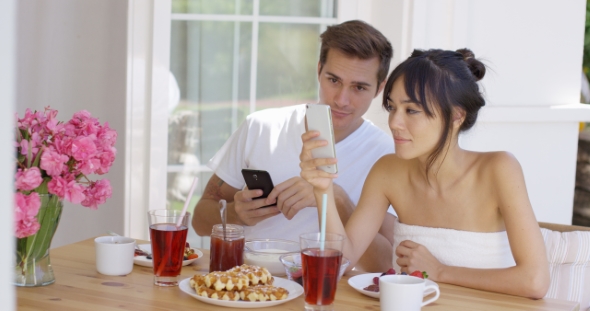 Woman Showing Man Something On Her Phone