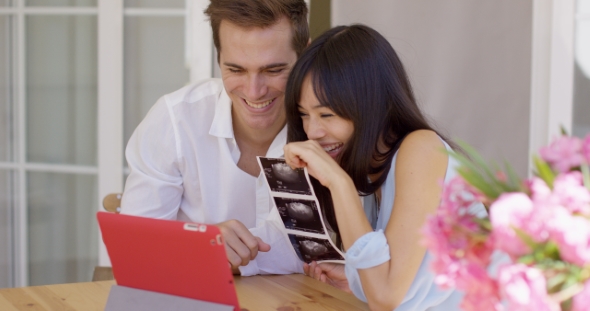 Happy Couple Showing Off Ultrasound Pictures