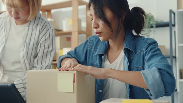 Young Asia businesswomen using mobile phone call receiving purchase order and check product on stock