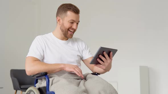 Disabled Man Sitting on Wheelchair and Talking on Video Chat