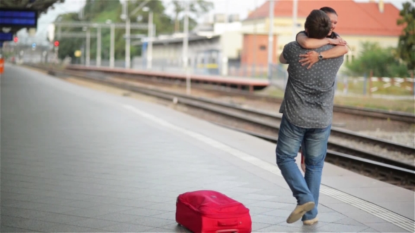 Young Couple Happy To Meet Again In The Train Station, Girl Runs To Meet Her Boyfriend And Throws a