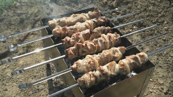 Meat Prepares On Metal Skewers On Coals Outdoors